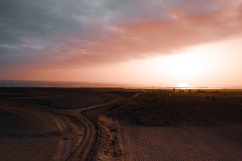 Ingyenes stockfotó földes út, mező, naplemente témában