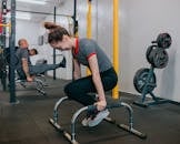 一群年轻人在室内激烈地使用健身器材锻炼