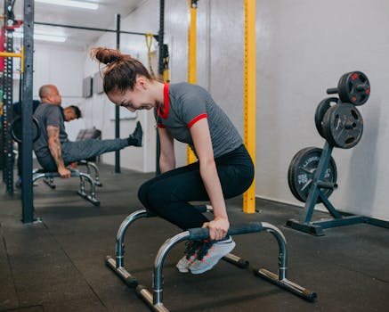 一群年轻人在室内激烈地使用健身器材锻炼