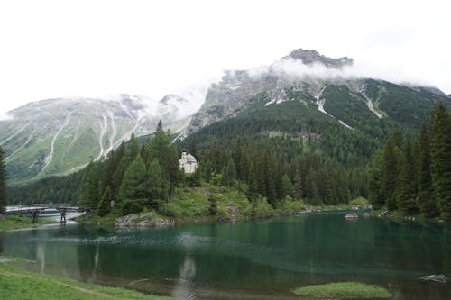 A lake with mountains in the background and a church