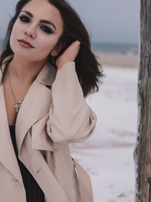 Portrait of Woman Fixing Hair in Trench Coat