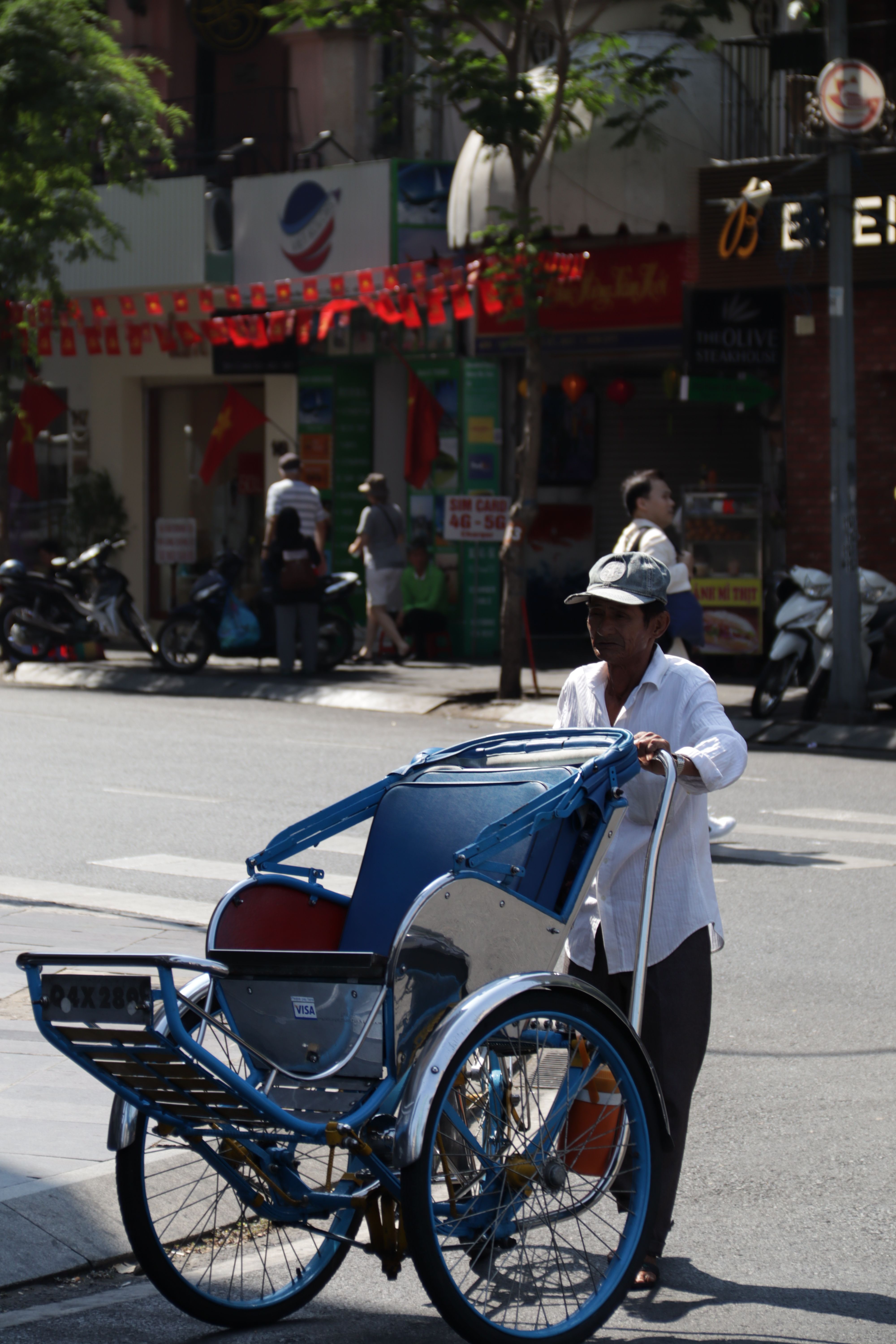 A Man Pushing an Empty Rickshaw on a Street in City · Free Stock Photo