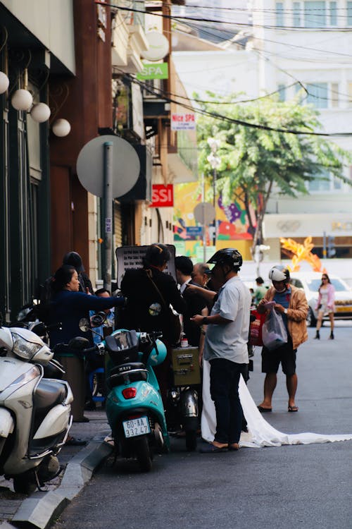 People with Motor Scooters on Street in City