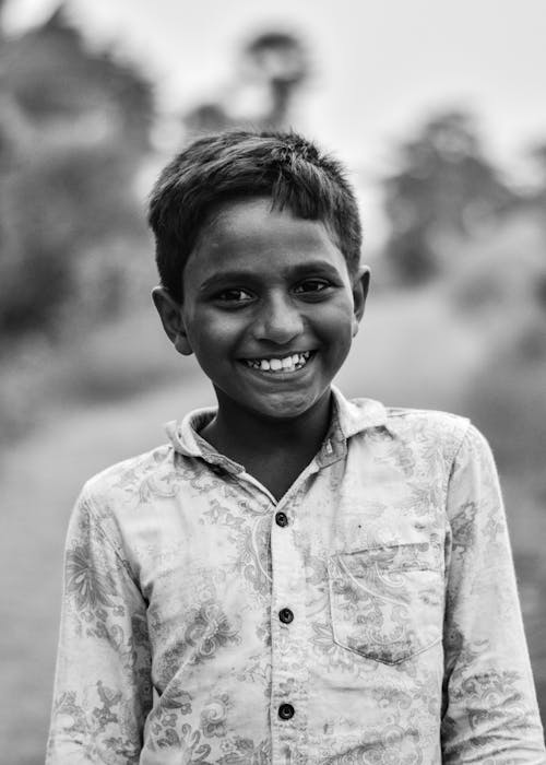 A black and white photo of a smiling boy