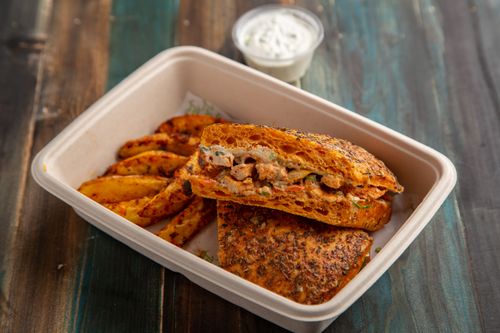 Free Delicious sandwich and spiced fries served in a compostable box, perfect for lunch or takeaway meals. Stock Photo