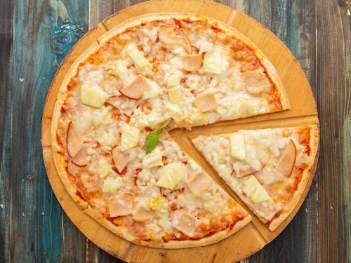 Top View of a Pizza on a Wooden Cutting Board 