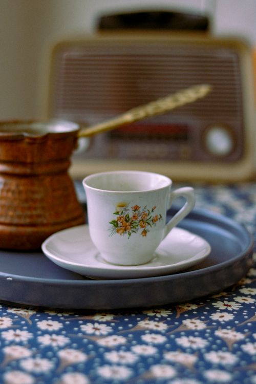 Free Detailed shot of a floral teacup on a tray with vintage elements and radio. Stock Photo