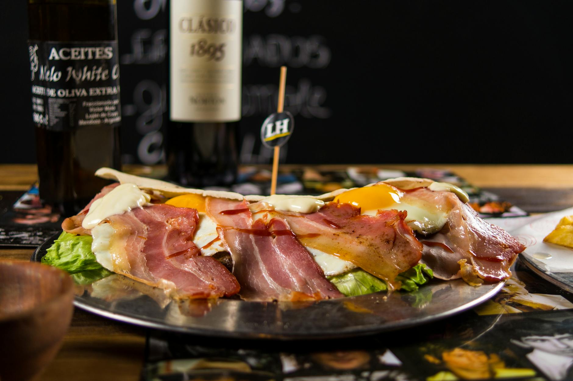 Delicious plate of bacon and eggs served with wine in a cozy Mendoza restaurant.