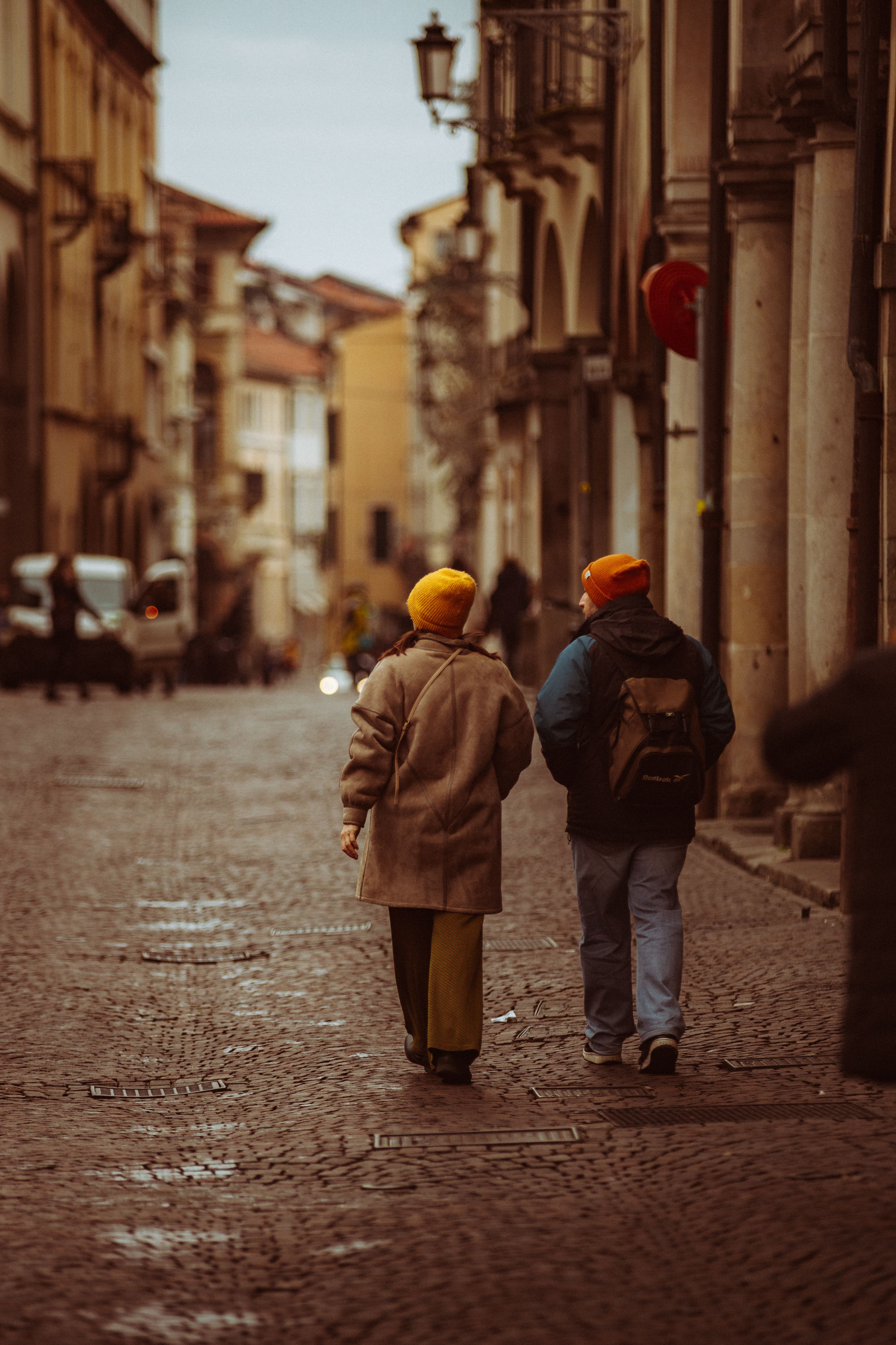 Back View of Couple Walking on Cobblestone Street · Free Stock Photo