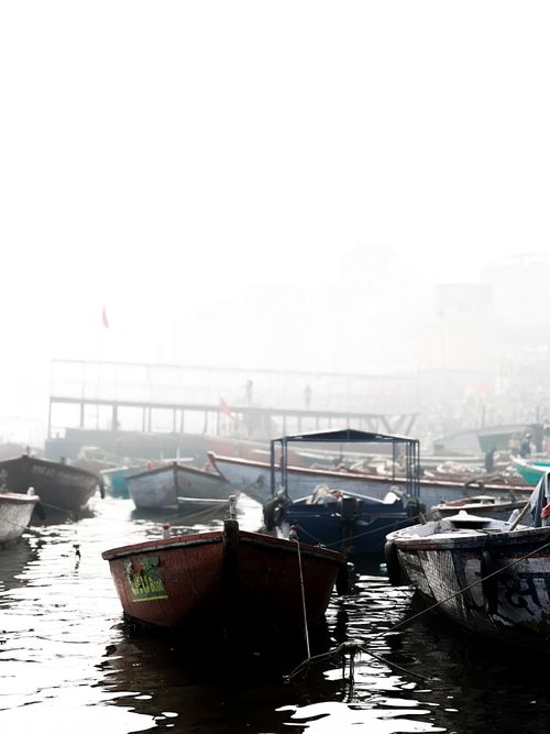 Free Serene view of boats moored in a foggy harbor creating a peaceful, reflective atmosphere. Stock Photo