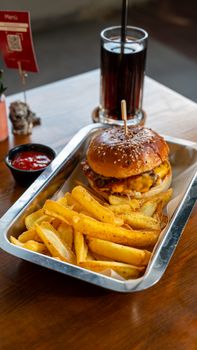 Savor a classic cheeseburger with crispy fries and soda in a casual dining setting.