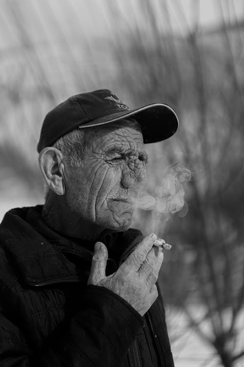 A man smoking a cigarette in black and white