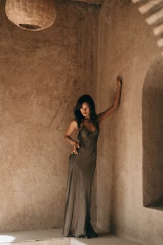 A woman in stylish attire posing against an ornate wall in Marrakesh, Morocco.