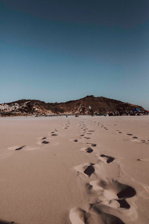 Footprints on Beach under Clear Sky