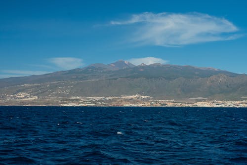 The view from the water of a mountain and a small island