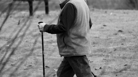 A senior man engaged in Nordic walking during a day in the park.