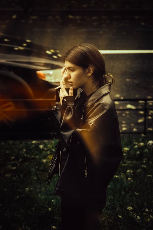 A woman in a leather jacket talking on her cell phone
