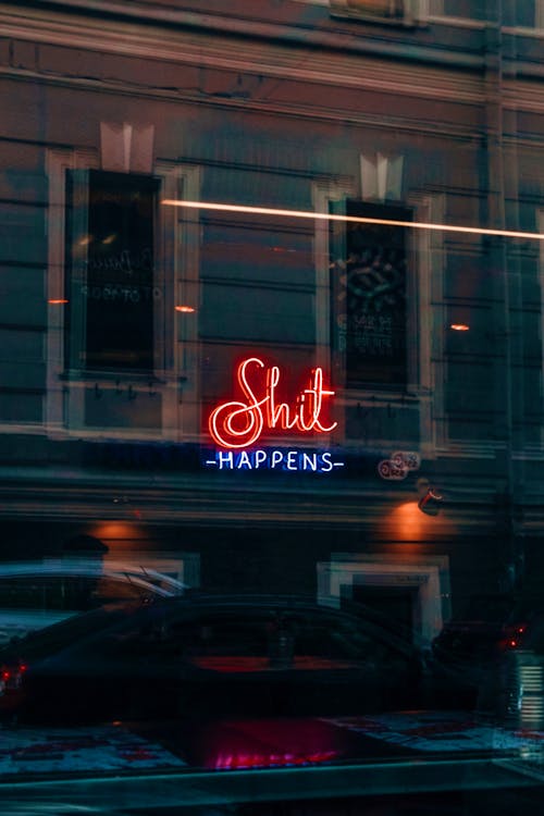 Neon sign that says shit happens