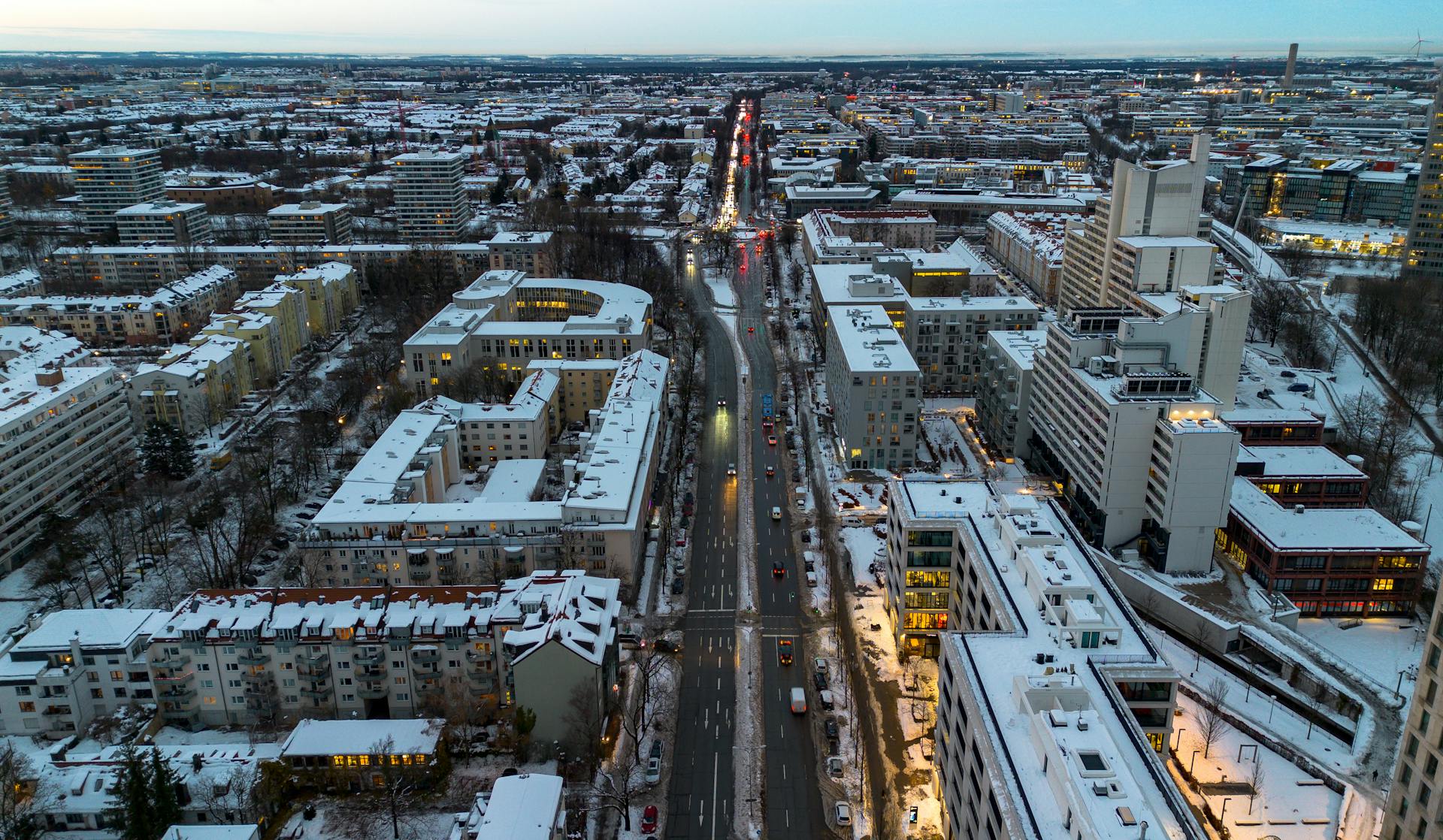 Aerial view of snow-covered Munich cityscape in winter, captured at dusk.