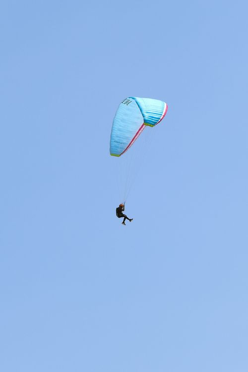 Free Experience a thrilling paragliding adventure against Varkala's clear blue skies. Stock Photo