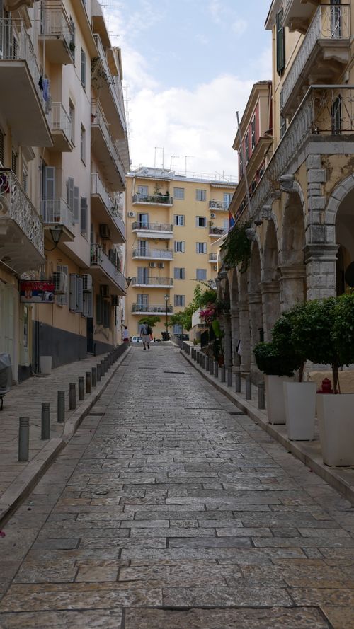 Free Discover the quaint architecture of a narrow alley in Corfu, Greece, lined with historical buildings. Stock Photo