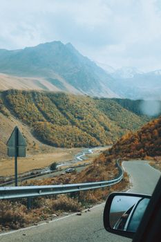 Breathtaking view of a winding mountain road through autumn foliage.
