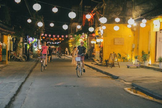 Cyclists enjoying a night ride through the lantern-lit streets of Hoi An, Vietnam.