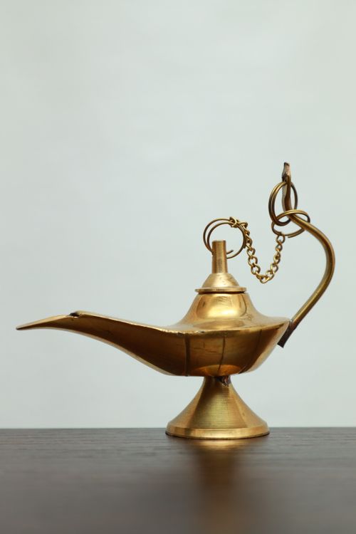 Free Intricately designed brass oil lamp reminiscent of Aladdin's classic genie lamp, perfect for vintage decor. Stock Photo