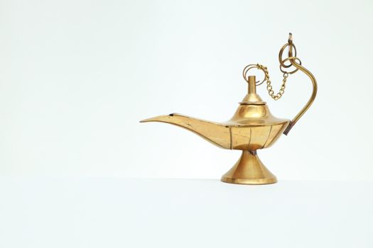Beautiful golden antique oil lamp representing traditional culture on a white background.