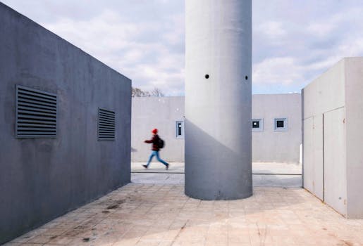 A person walking in a modern urban setting with minimalist grey architecture in Istanbul.
