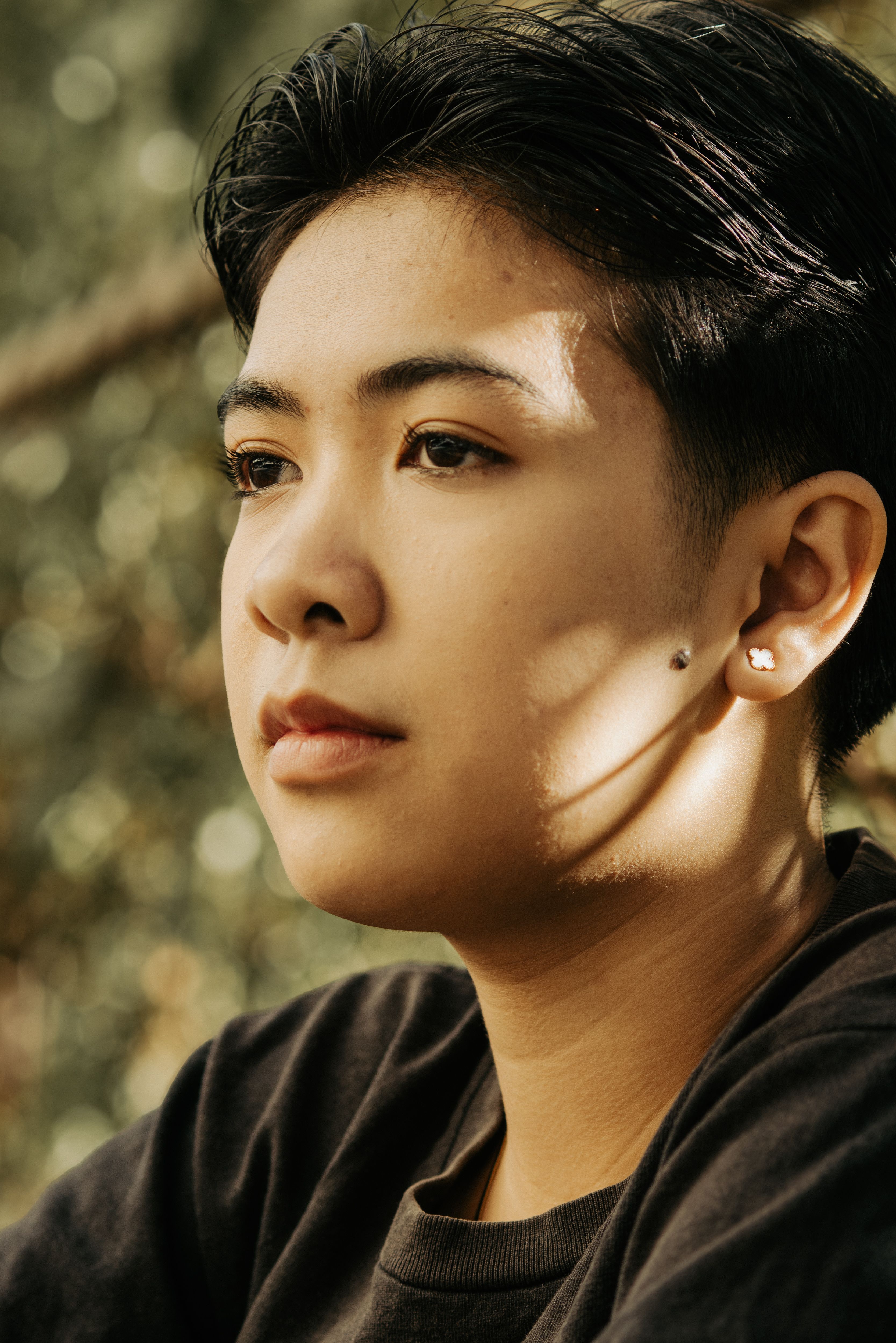 Close-up portrait of an Asian woman with short black hair, captured in natural light.