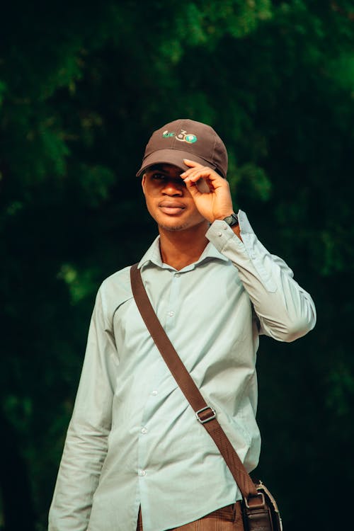 Free A man wearing a hat and sunglasses is standing in the woods Stock Photo