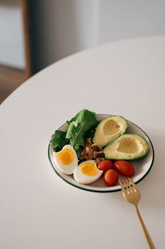Delicious salad with avocado, boiled egg, walnuts, spinach, and cherry tomatoes.