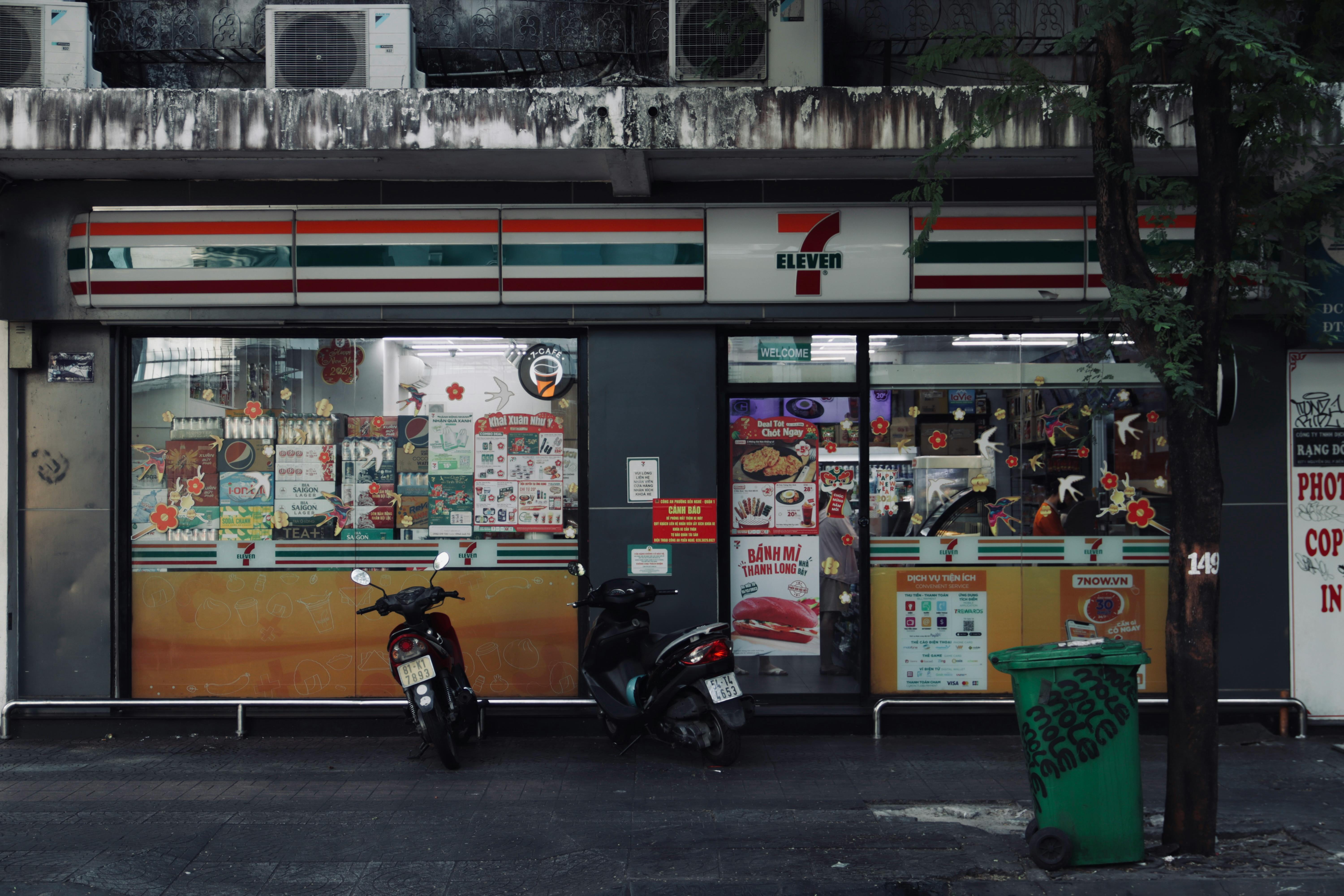 Explore the vibrant storefront of an urban convenience store captured at dusk, showcasing dynamic urban life.