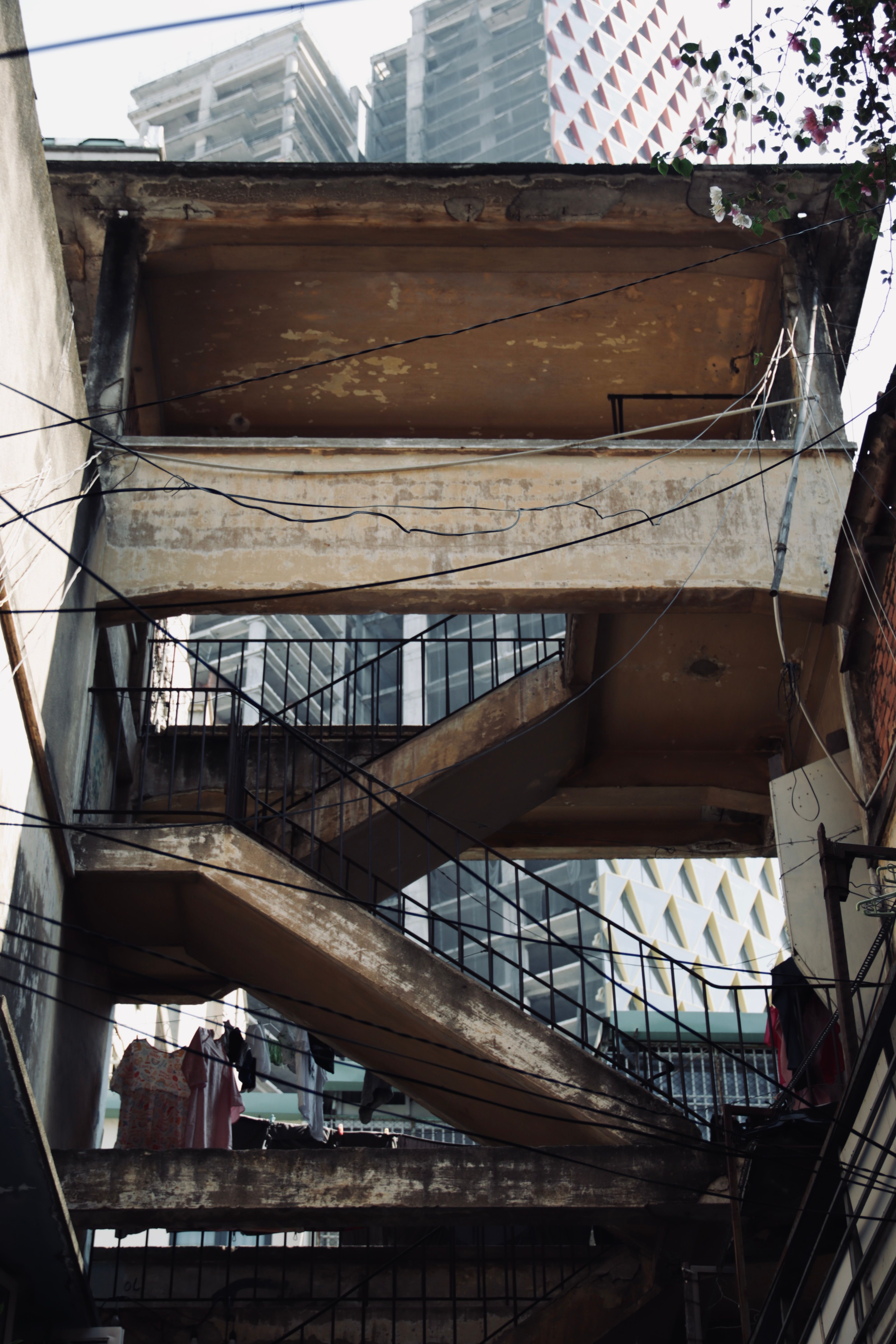 Low angle shot of an abandoned building featuring concrete stairs in an urban setting.