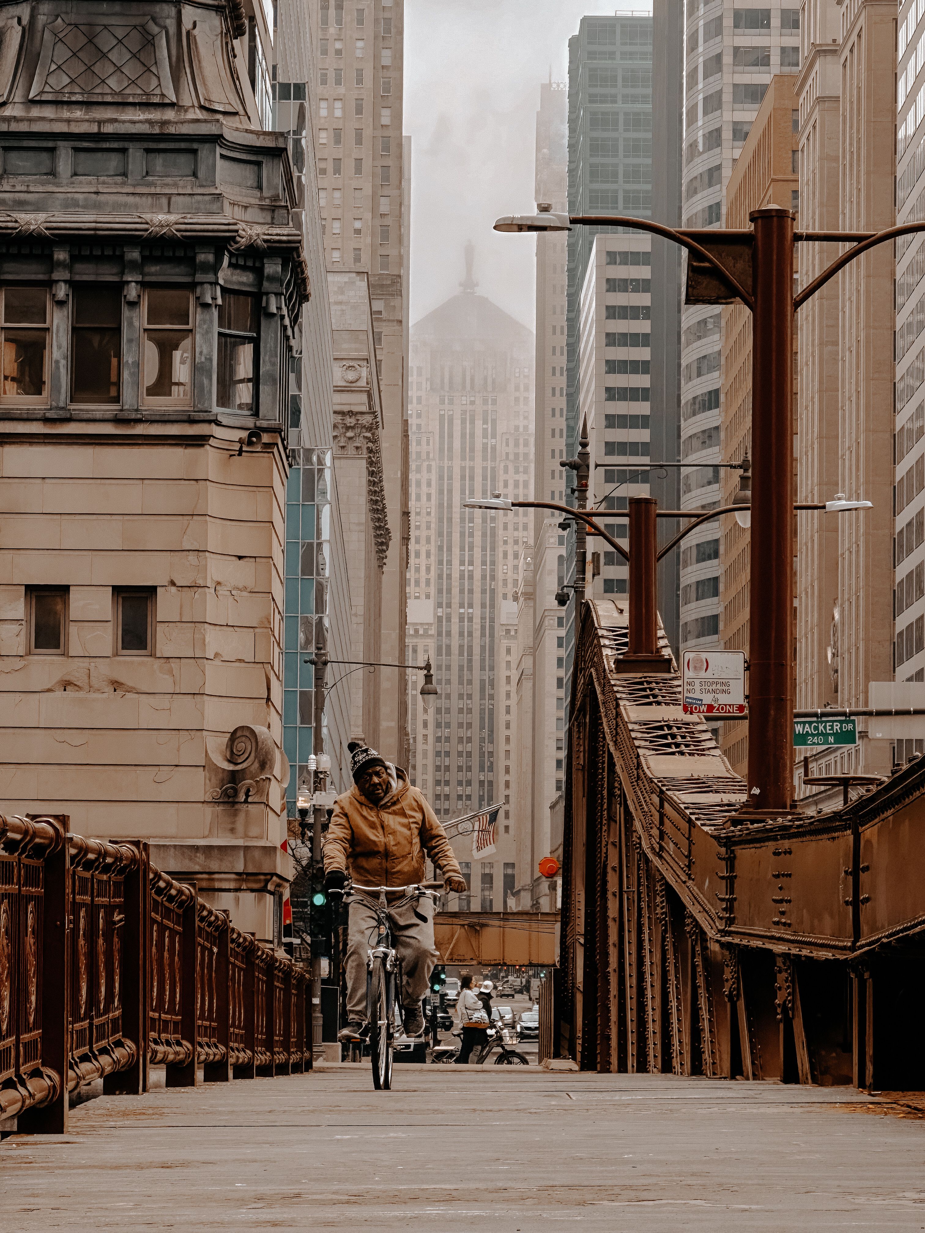 A man cycling through downtown Chicago's urban landscape with skyscrapers in the background.