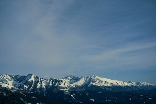 A scenic view of a snowcapped mountain range under a clear blue sky.