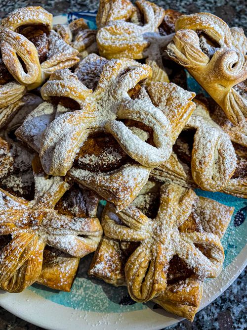 Free Delicious pastries freshly baked and dusted with powdered sugar, perfect for dessert. Stock Photo
