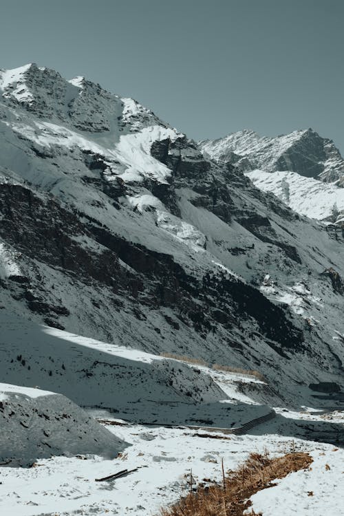 A snow covered mountain range with a road running through it