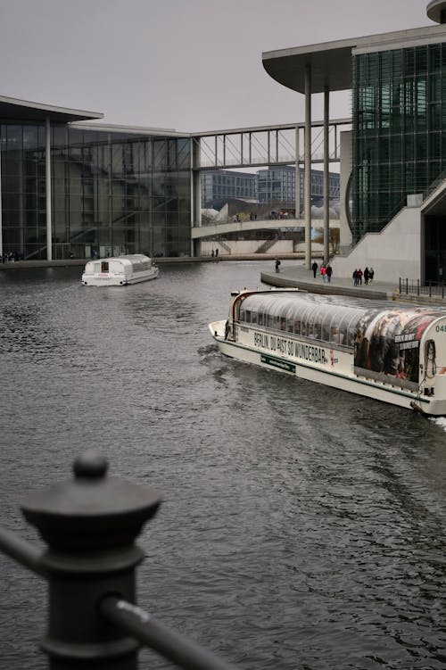 A boat is traveling down a river near a building