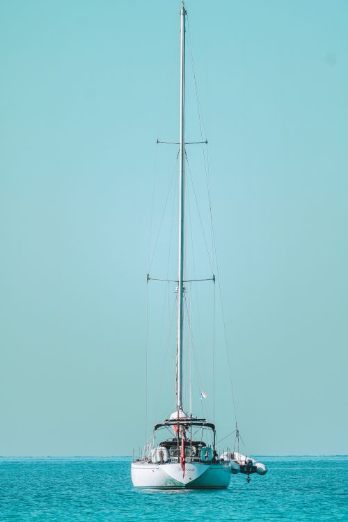 Free A lone sailing boat on the tranquil sea under a clear blue sky in Ko Kut, Thailand. Stock Photo