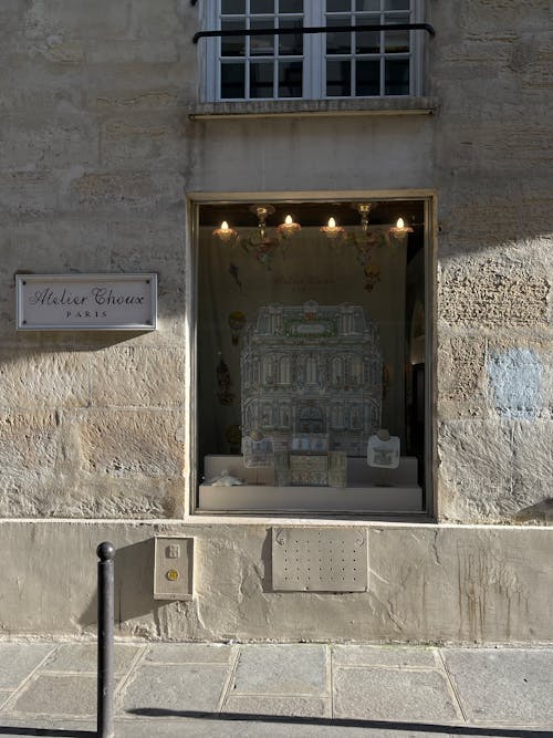 A window with a sign on it and a stone building