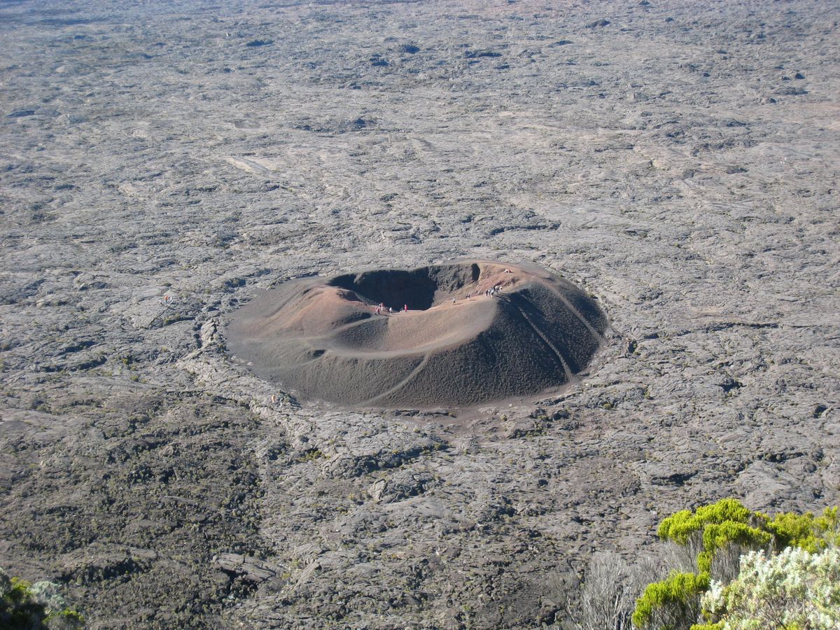 Cône volcanique du Formica Leo entouré de lave figée dans l'Enclos Fouqué