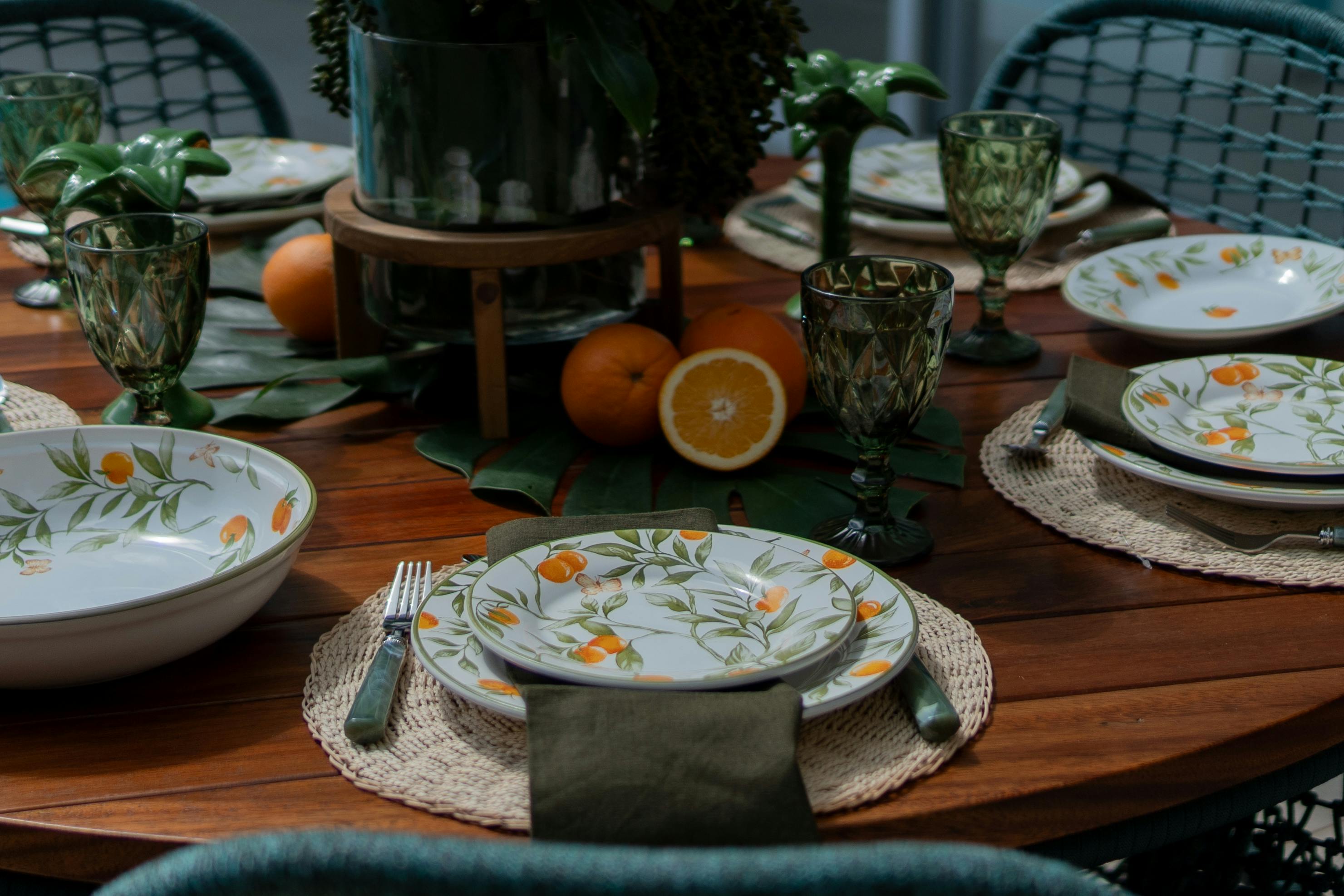 Stylish dining table setup featuring citrus-themed tableware and lush greenery, perfect for a fresh spring dinner.