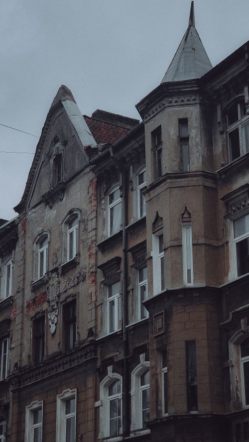 Free A moody urban shot of a historic building facade under a cloudy sky. Stock Photo