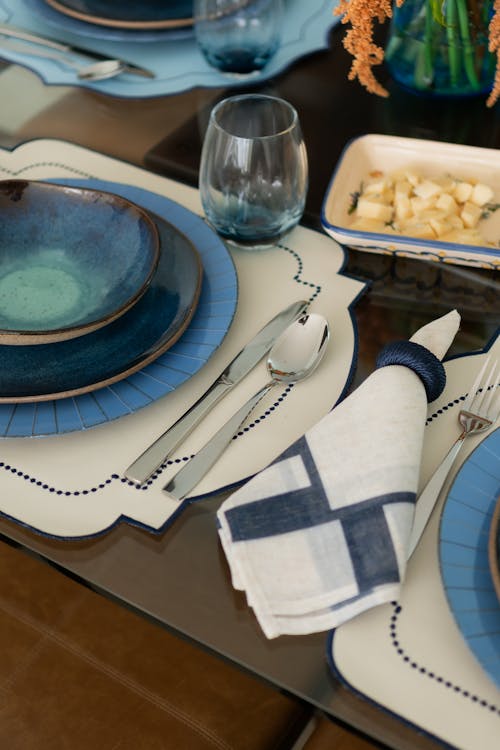 A table setting with blue and white plates and silverware