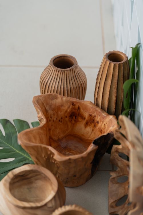 Free A collection of rustic wooden bowls and vases complemented by a monstera leaf, highlighting natural decor. Stock Photo