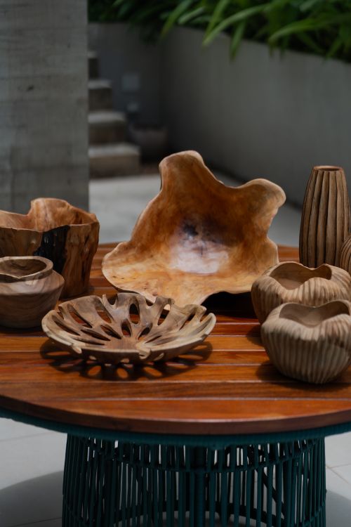 Free A collection of carved wooden decorative bowls and vases on an outdoor table. Stock Photo