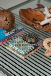 Aesthetic tabletop display with books, patterned box, and wooden decor elements.