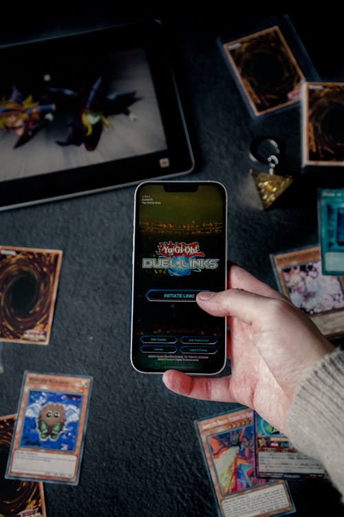 A hand holding an iPhone with the game "Yu-Gi-Oh! Duel Links" playing on the display || Yu-Gi-Oh! Card Game 25th Anniversary ||  Jovan Vasiljević Photography